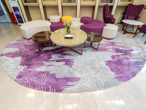 a room with a table and chairs and a purple rug at Lavande Hotel Huizhou Shiwan in Huizhou