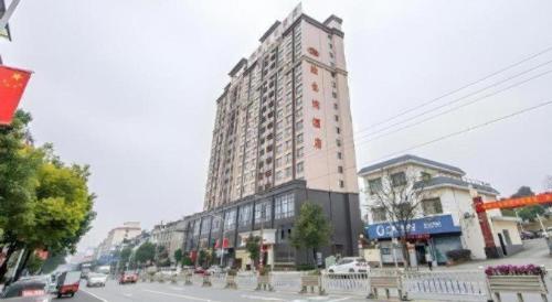 a large tall building on a city street with cars at Vienna Hotel Guangxi Guilin Xing'an in Guilin