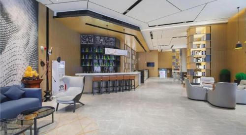 a lobby with chairs and a bar in a library at Echarm Hotel Changsha Wuyi Square Xiangya Affiliated 1st Provincial Maternity and Child in Changsha