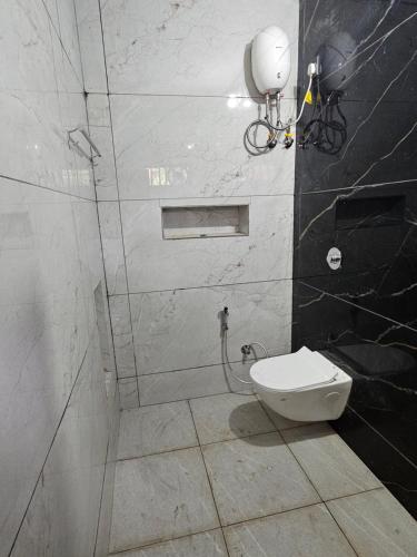 un baño con inodoro y ducha en Aadhya Serenity Homestay, en Honāvar