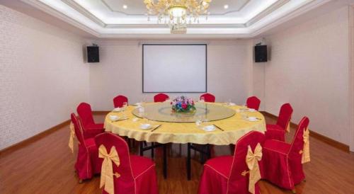 a conference room with a table and red chairs at Vienna Hotel Guangdong Shantou South Bus Station in Shantou