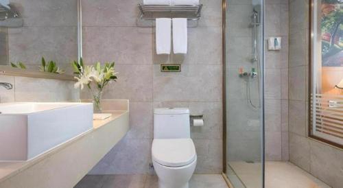 a bathroom with a toilet and a sink and a shower at Vienna Hotel Hubei Jinzhou Changjiang University in Caoshi