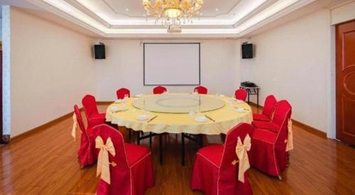a conference room with a table and red chairs at Vienna Hotel Guangdong Shantou South Bus Station in Shantou