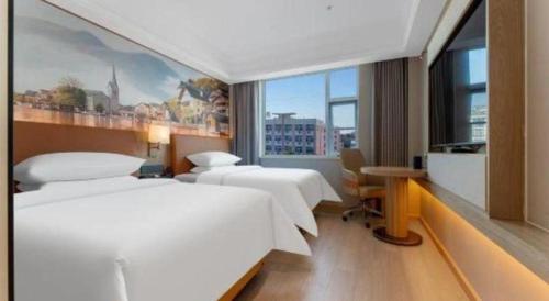 a hotel room with two beds and a window at Vienna Hotel Hubei Jinzhou Changjiang University in Caoshi