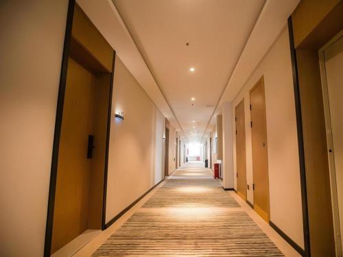 an empty hallway with a long aisle in a building at Green Tree Inn Luoyang Fenghuang Mansion Mudan Square Metro Station in Luoyang