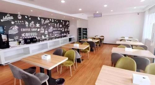 a restaurant with tables and chairs and a chalkboard at Green Tree Inn Luoyang Fenghuang Mansion Mudan Square Metro Station in Luoyang