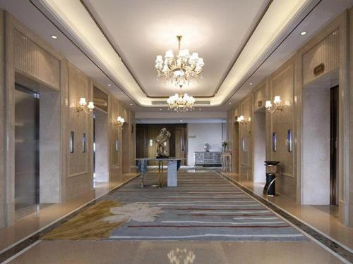 a hallway with a chandelier and a large rug at Venus Royal Hotel Nanning East High-Speed Railway Station in Nanning