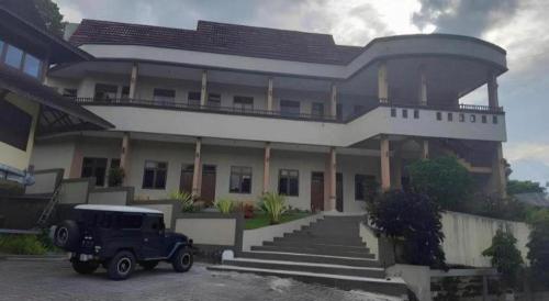 an old car parked in front of a building at Sapadia Hotel Parapat in Parapat