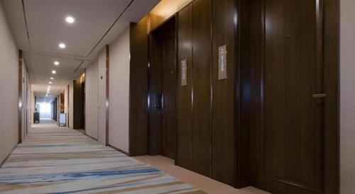 a hallway with wooden doors and a rug on the floor at Venus Royal Hotel Nanning East High-Speed Railway Station in Nanning