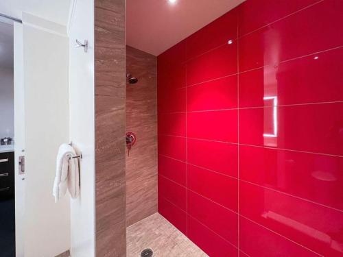 a red shower stall with a red wall in a bathroom at Ahern Hotel and Event Center in Las Vegas