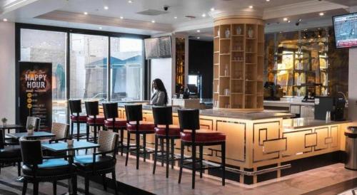 a woman sitting at a bar in a restaurant at Ahern Hotel and Event Center in Las Vegas