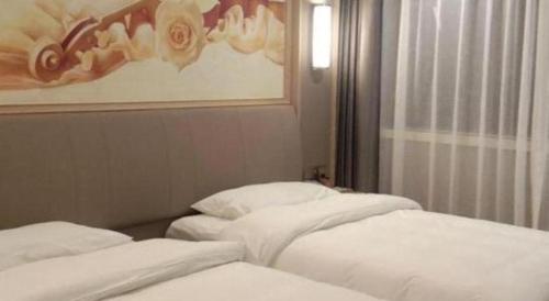 two white beds in a room with a window at Vienna Hotel Zhejiang Lishui Qingtian Post Building in Lishui