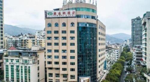 a tall building with a sign on top of it at Vienna Hotel Zhejiang Lishui Qingtian Post Building in Lishui