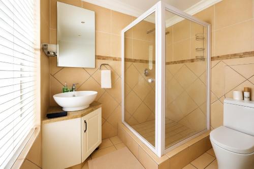 a bathroom with a shower and a sink at Surf & Serenity on Sea, by Jono & Erik in Jeffreys Bay