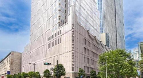 a tall white building in the middle of a city at Ginza Bellevue Hotel in Tokyo