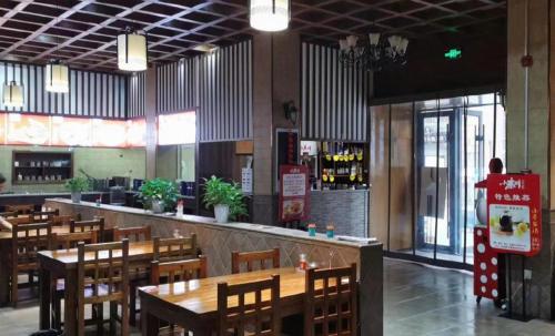 a restaurant with wooden tables and a bar at GreenTree Inn Luoyang Henan University of Science and Technology in Luoyang