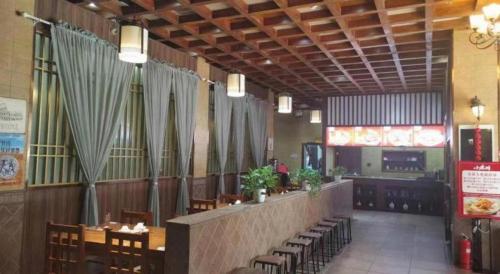 a restaurant with tables and chairs and a bar at GreenTree Inn Luoyang Henan University of Science and Technology in Luoyang
