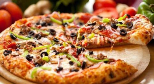 two slices of pizza on a wooden cutting board at Lotus Furnished Hotel Apartments LLC. Ajman in Ajman 