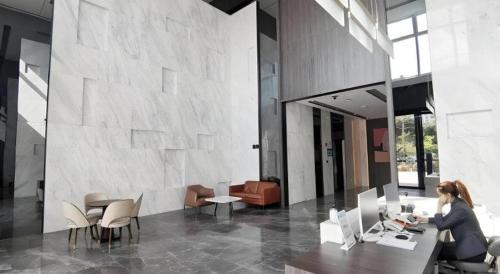 a woman sitting at a table in a lobby at F-TOWN Fangtang Hotel (Shenzhen Longgang Tian'an Digital City Huanggekeng Subway Station) in Shenzhen
