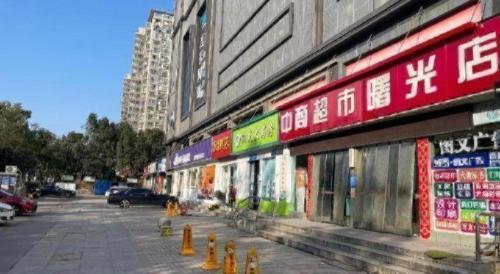 a building with signs on the side of a street at JTOUR Inn Wuhan Textile University in Wuhan