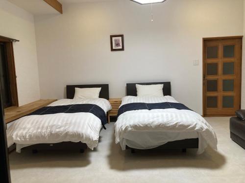 two beds sitting in a room with at 民泊絹家 in Izume