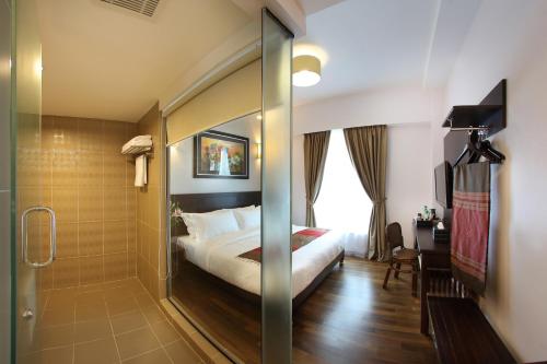 a hotel room with a bed and a shower at Hotel Richbaliz Selayang in Batu Caves