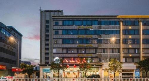 a large building with a sign in front of it at Bashan Hotel in Xiamen