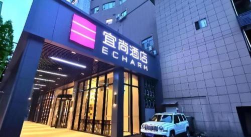 a white jeep parked in front of a building at Echarm Hotel Wuhan Gaotie Jianshe 2nd Road Metro Exit in Wuhan
