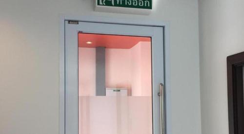 a glass door with a mirror in a room at The Grace Residence in Surin
