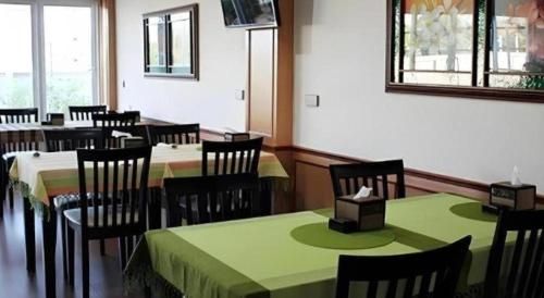 a dining room with tables and chairs and a mirror at Siamtara Palace Hotel in Maha Sarakham