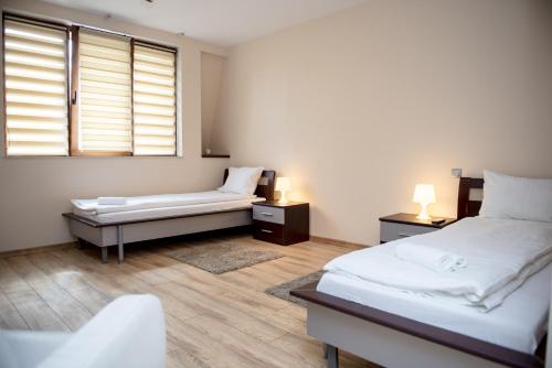 a bedroom with a bed and a bench and a window at Luxe Stay in Târgu-Mureş