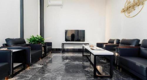 a living room with couches and a tv and a table at Borrman Hotel Changzhi Medical College Wulong Campus High-speed Railway South Station in Changzhi