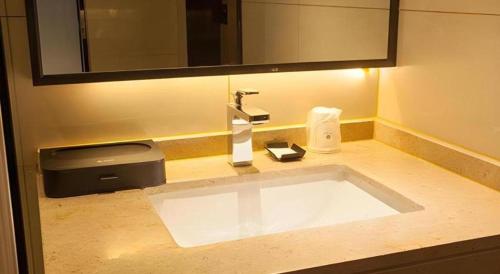 a bathroom counter with a sink and a mirror at City Comfort Inn Suzhou Wujiang Development Zone Yundong in Suzhou