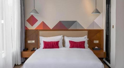 a bedroom with a large bed with red pillows at Borrman Hotel Guilin Railway Station Two Rivers and Four Lakes in Guilin