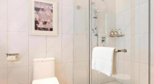 a white bathroom with a shower and a toilet at Borrman Hotel Guilin Railway Station Two Rivers and Four Lakes in Guilin