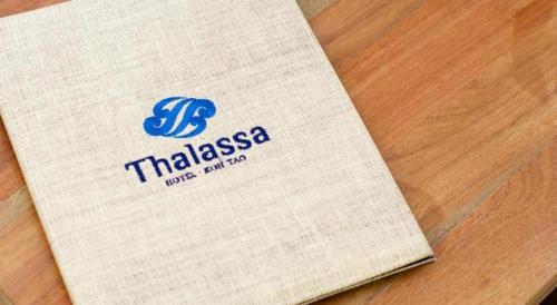 a book sitting on top of a wooden table at Thalassa Hotel in Koh Tao