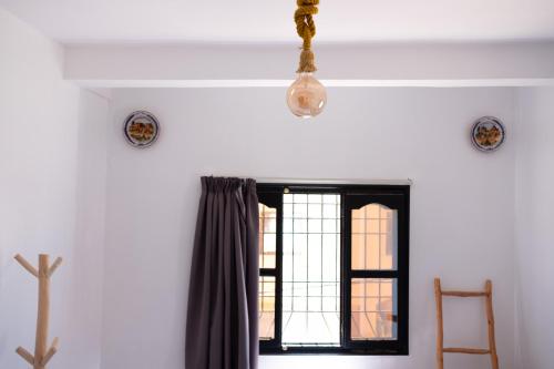 a room with a window and a chandelier at Azurf - Imsouane Surf House in Imsouane