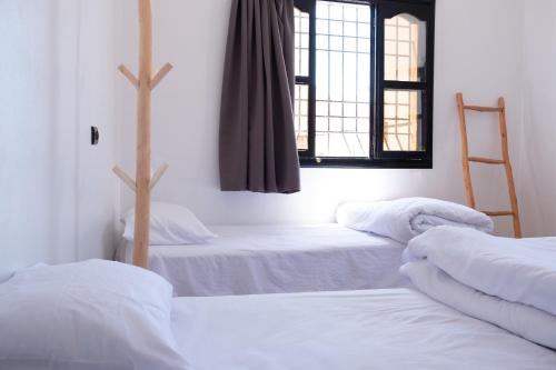 a room with two beds and a window at Azurf - Imsouane Surf House in Imsouane