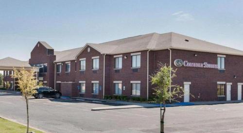 a large red brick building with a car parked outside at Comfort Suites in Plainview
