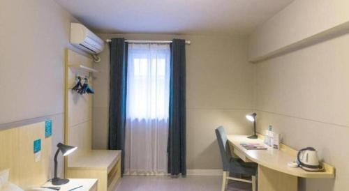 a hospital room with a desk and a window at Jinjiang Inn Jiaxing South Lake in Jiaxing