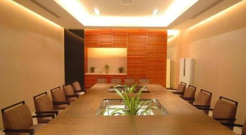 a conference room with a long wooden table and chairs at Jinjiang Inn Jiaxing South Lake in Jiaxing