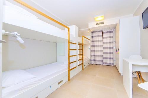a bedroom with a bunk bed and a desk at Hostel Dvor in Split