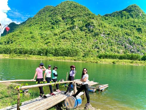 a group of people standing on a bridge over a river at Little Rock Homestay in Phong Nha
