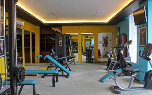 a gym with several treadmills and exercise machines at Grand Surya Hotel Kediri in Kediri
