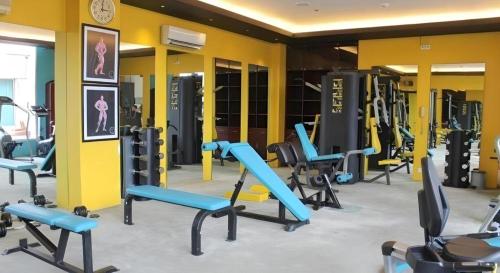 a gym with a bunch of treadmills and machines at Grand Surya Hotel Kediri in Kediri