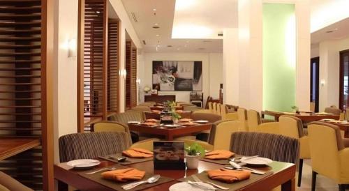 a dining room with tables and chairs in a restaurant at Grand Surya Hotel Kediri in Kediri