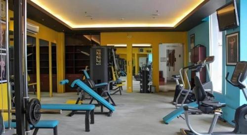 a gym with a bunch of treadmills and machines at Grand Surya Hotel Kediri in Kediri