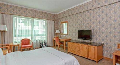 a hotel room with a bed and a flat screen tv at New Pearl River Hotel in Guangzhou