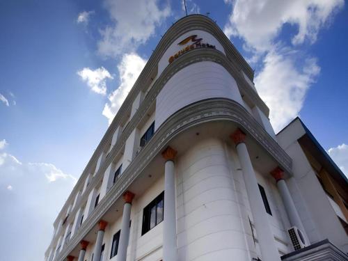 a white building with a tower on top of it at Garuda Hotel Pontianak in Pontianak