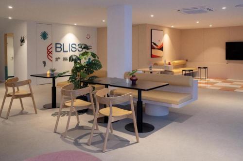 a room with a table and chairs and a couch at 777Bliss Hometel in Nakhon Phanom